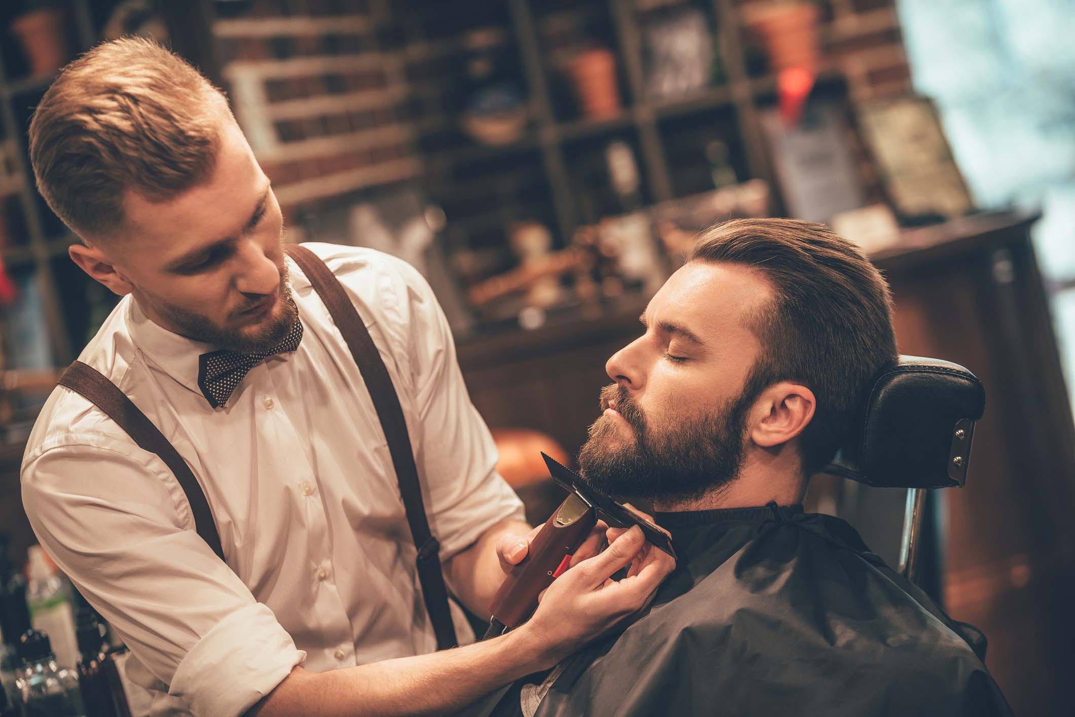 Gentleman with a barber getting a beard trim